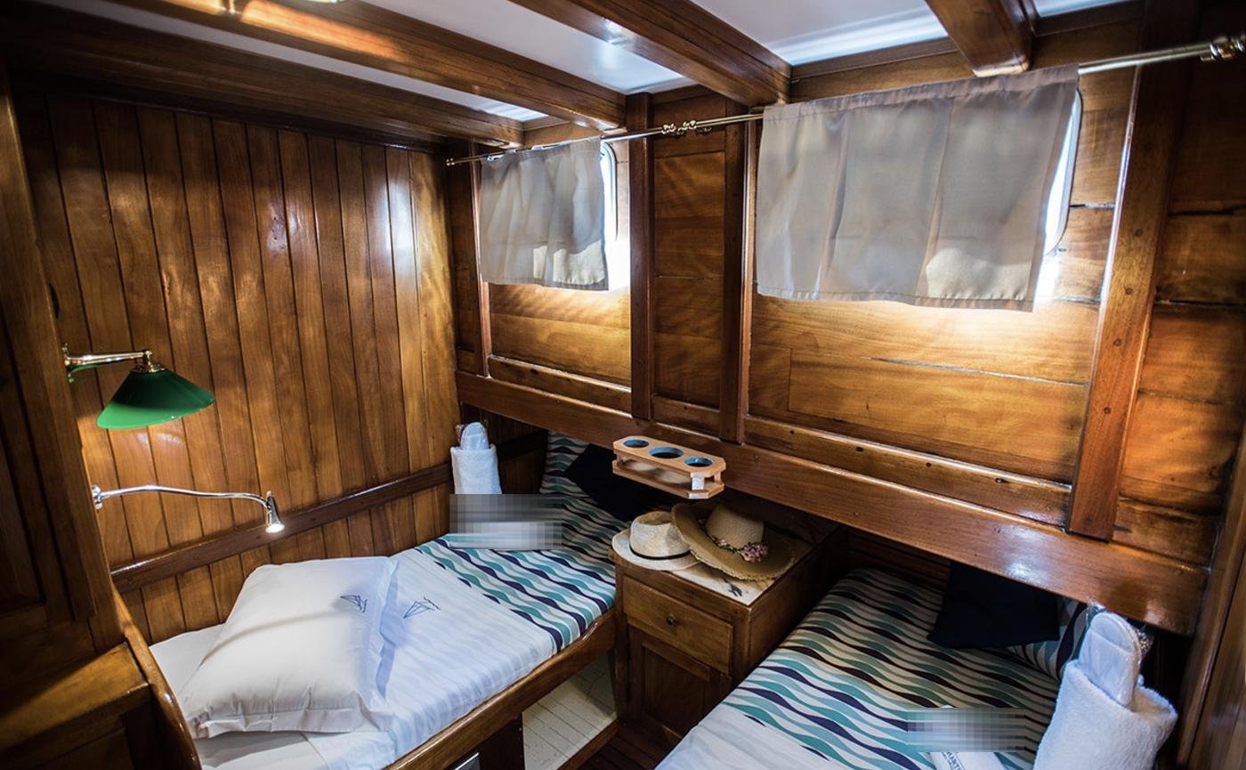 Twin cabin with two berths and curtained portlights on the Positano gulet charter