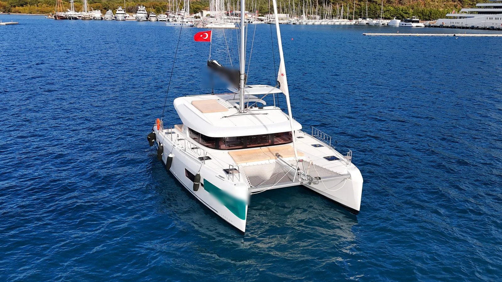 Lagoon 42 sailing catamaran charter Marmaris approaching marina with Turkish coastline in background