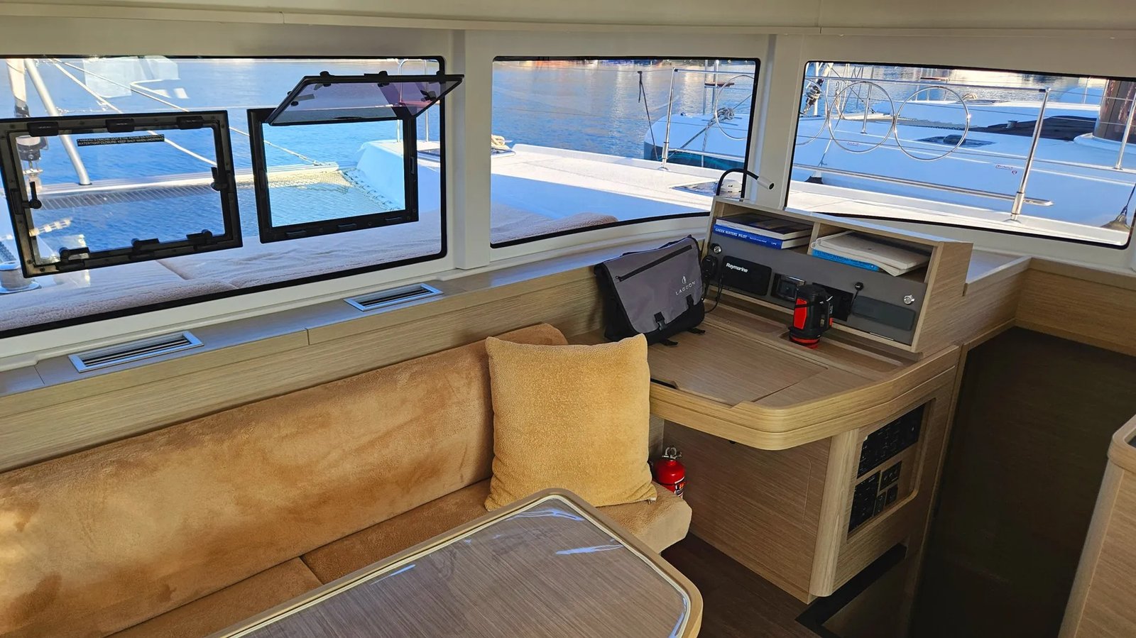 Lagoon 42 catamaran salon interior with wraparound windows and marina view, Marmaris charter yacht MA1305