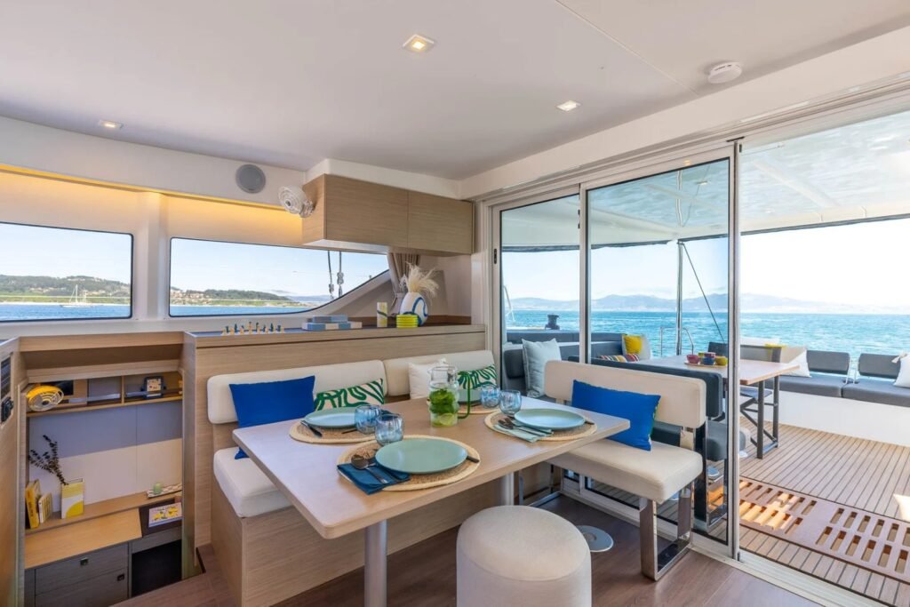 Lagoon 43 catamaran saloon dining table with sliding door open to the aft cockpit, Kos charter AL1406