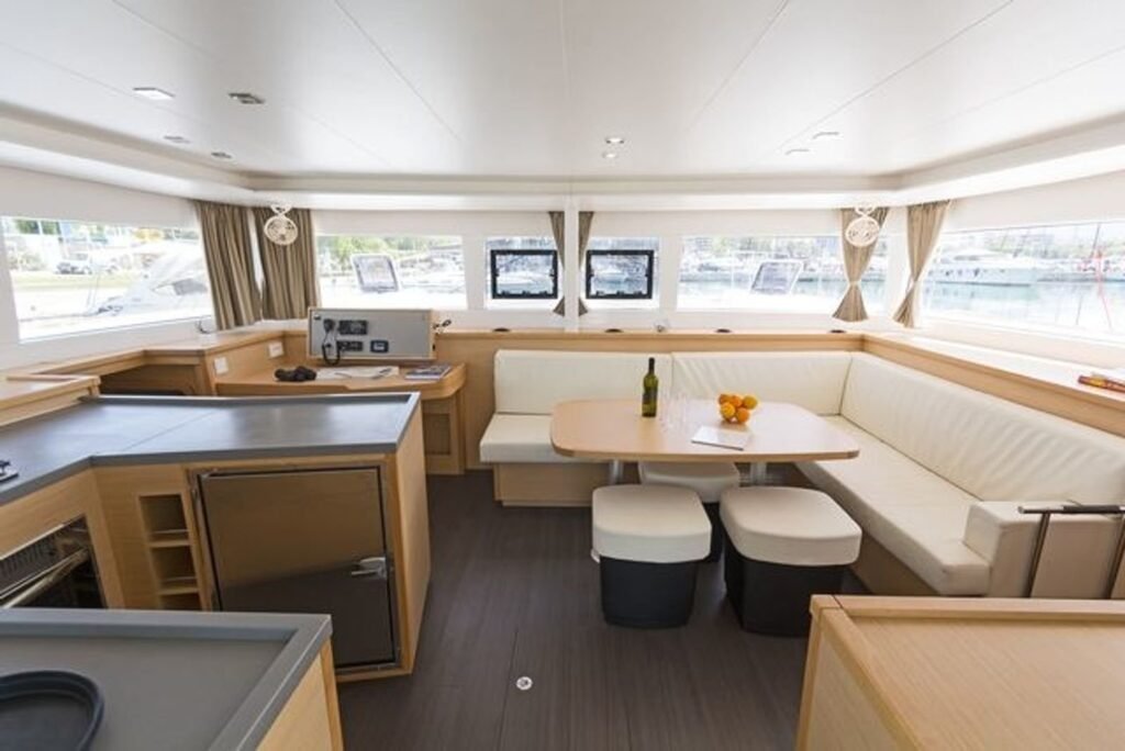 Lagoon 450 F katamaran NE1406'da U biçimli oturma grubu, yemek masası ve seyir istasyonlu salon, İstanköy
