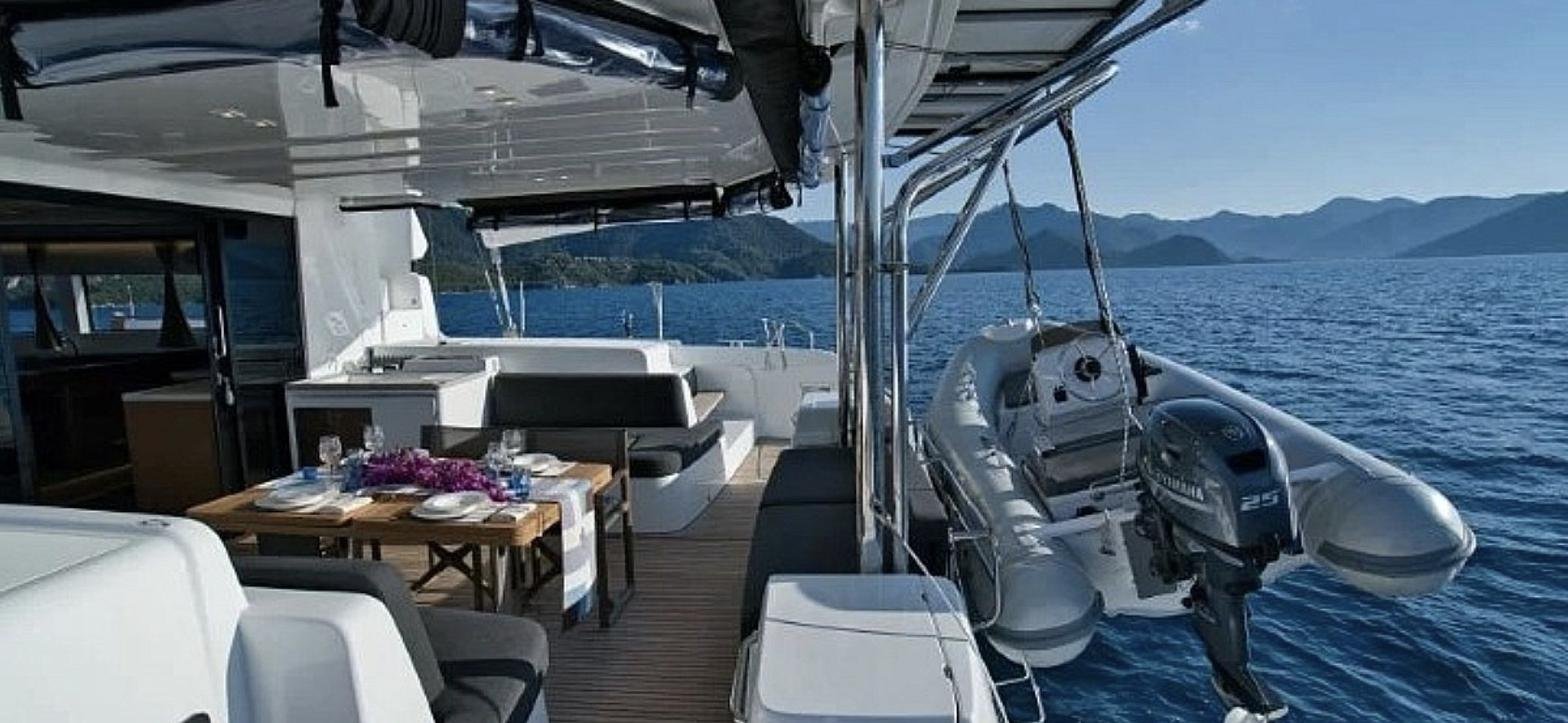 Aft deck with dining table and davit tender on a 15m Lagoon 50 catamaran