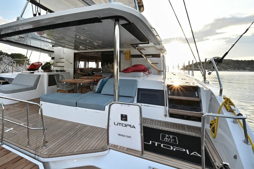 Lagoon 55 catamaran saloon lounge with sofa, coffee table and navigation station beneath panoramic windows, Kos charter UT1704