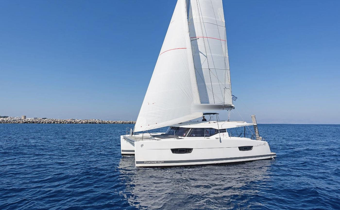 Rodos dalgakıranı açıklarında tam yelkenle seyreden kiralık Lucia 40 katamaran