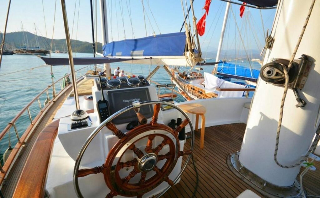 Luxury gulet charter Göcek — classic wooden ship's wheel and helm station