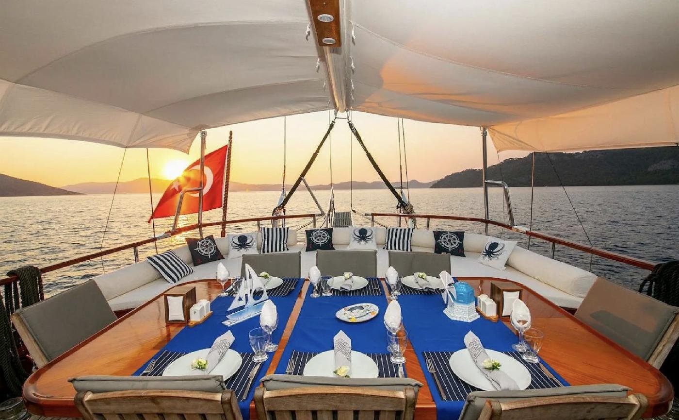 Aft deck dining table laid at sunset on a luxury gulet charter Selimiye
