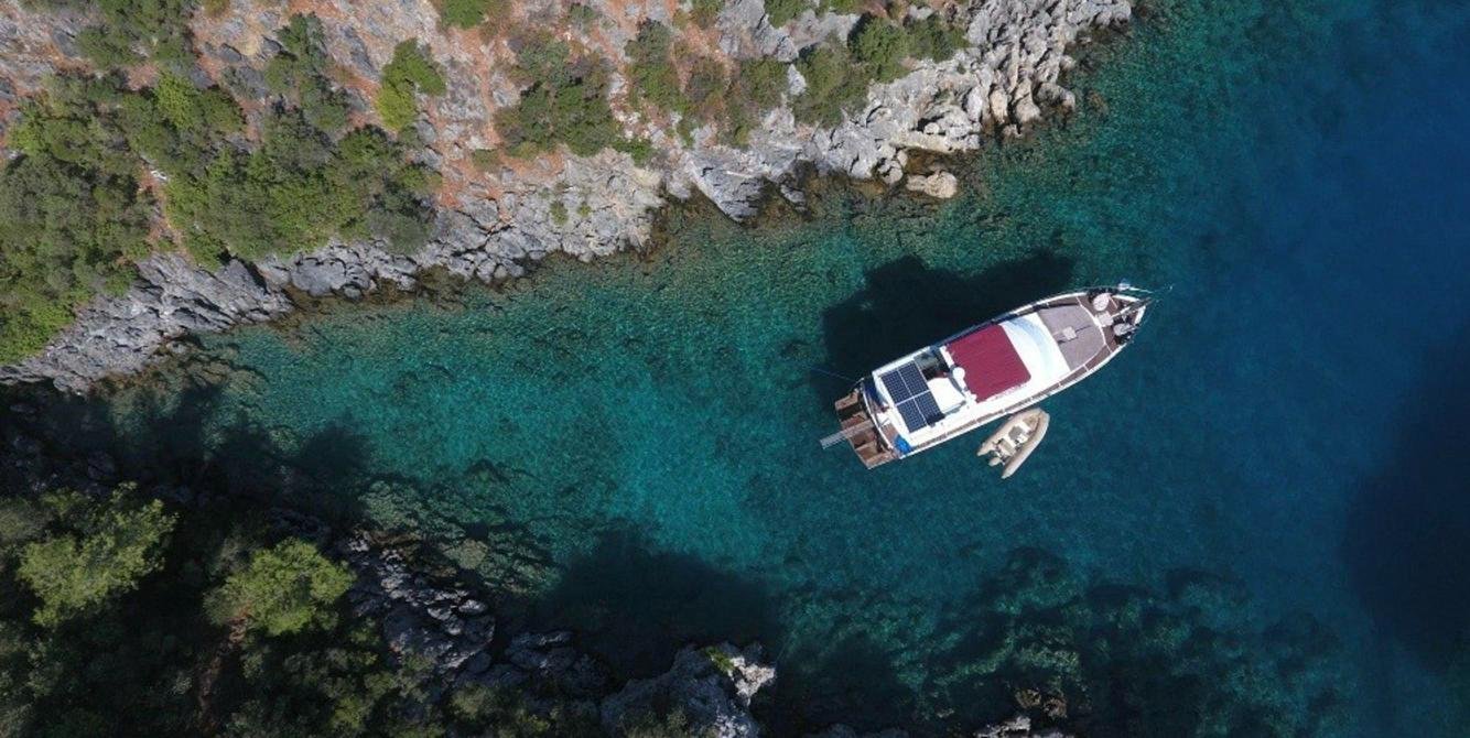 Aerial of a luxury yacht charter in Fethiye anchored in a turquoise cove