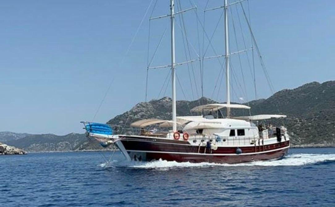 Modern gulet charter Bozburun - motor gulet under way off a rocky coast