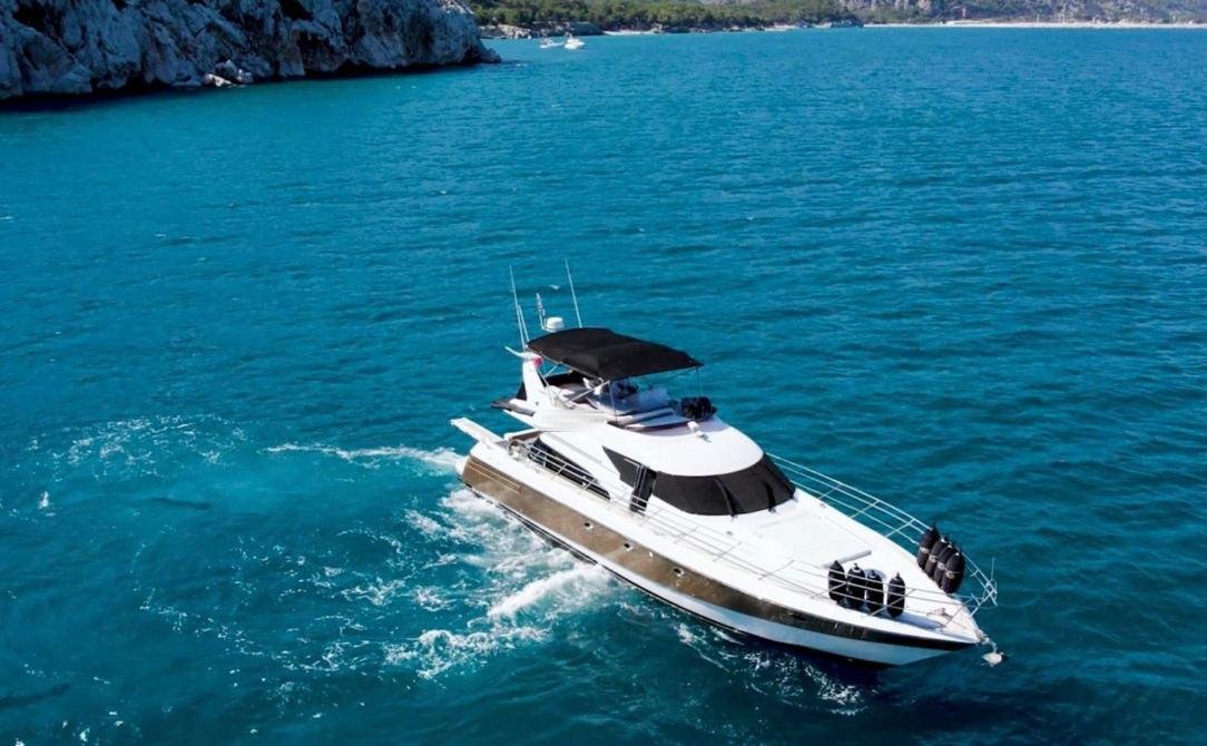 Motor yacht charter Antalya: 19-metre flybridge motor yacht under way in a turquoise Lycian bay