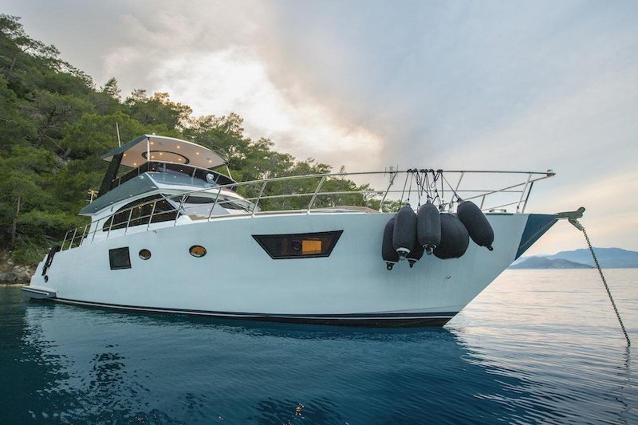 Profile view of a luxury motor yacht hull at anchor near Fethiye, Turkey