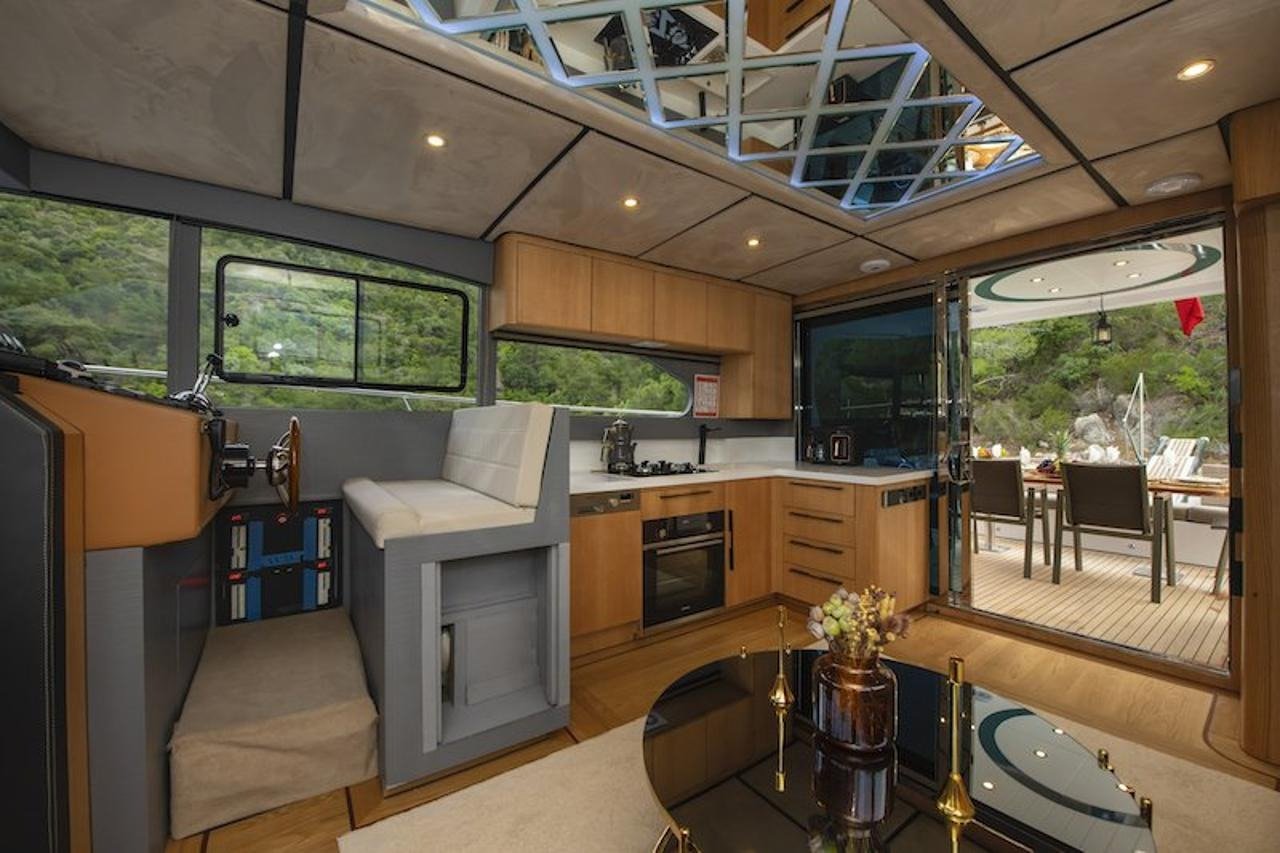 Lower helm station beside the galley aboard a luxury motor yacht with the aft deck open to a Fethiye anchorage