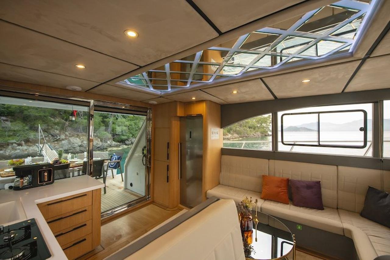 Open-plan saloon and galley aboard a luxury motor yacht with sliding doors onto the cockpit in Fethiye