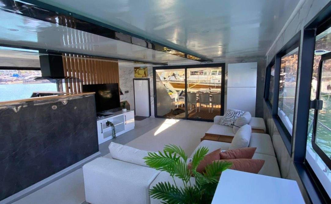 Main saloon with corner sofa and television