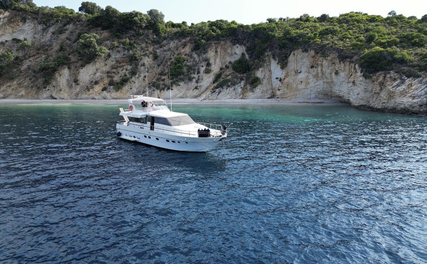 Motor yacht charter Lefkada at anchor off a white limestone cliff beach