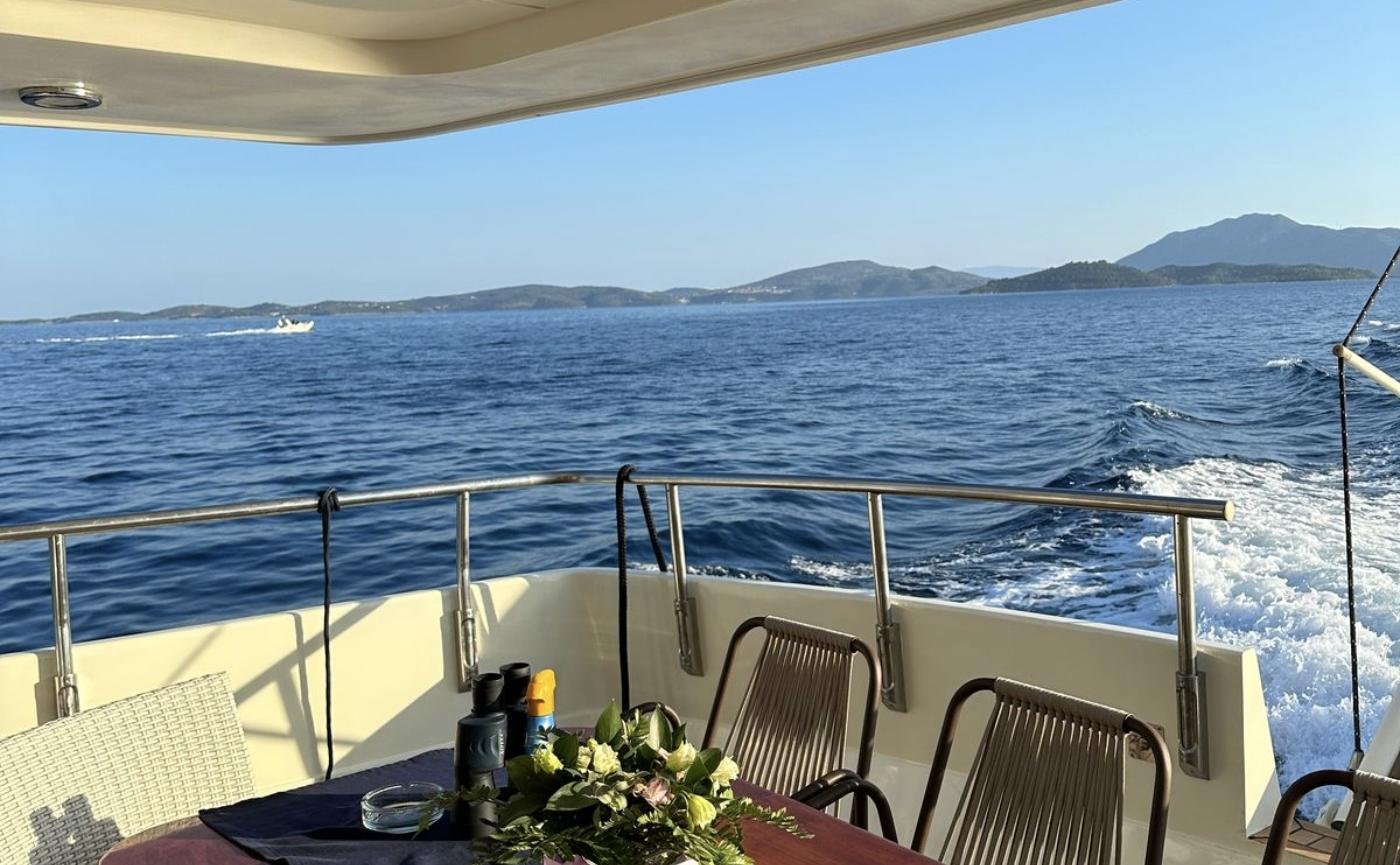 Aft deck table under way on the motor yacht charter Lefkada looking back at the wake