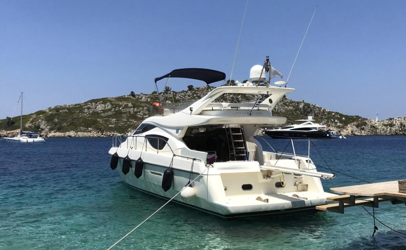 Flybridge motor yacht charter Paros lying stern-to in a clear Cycladic cove