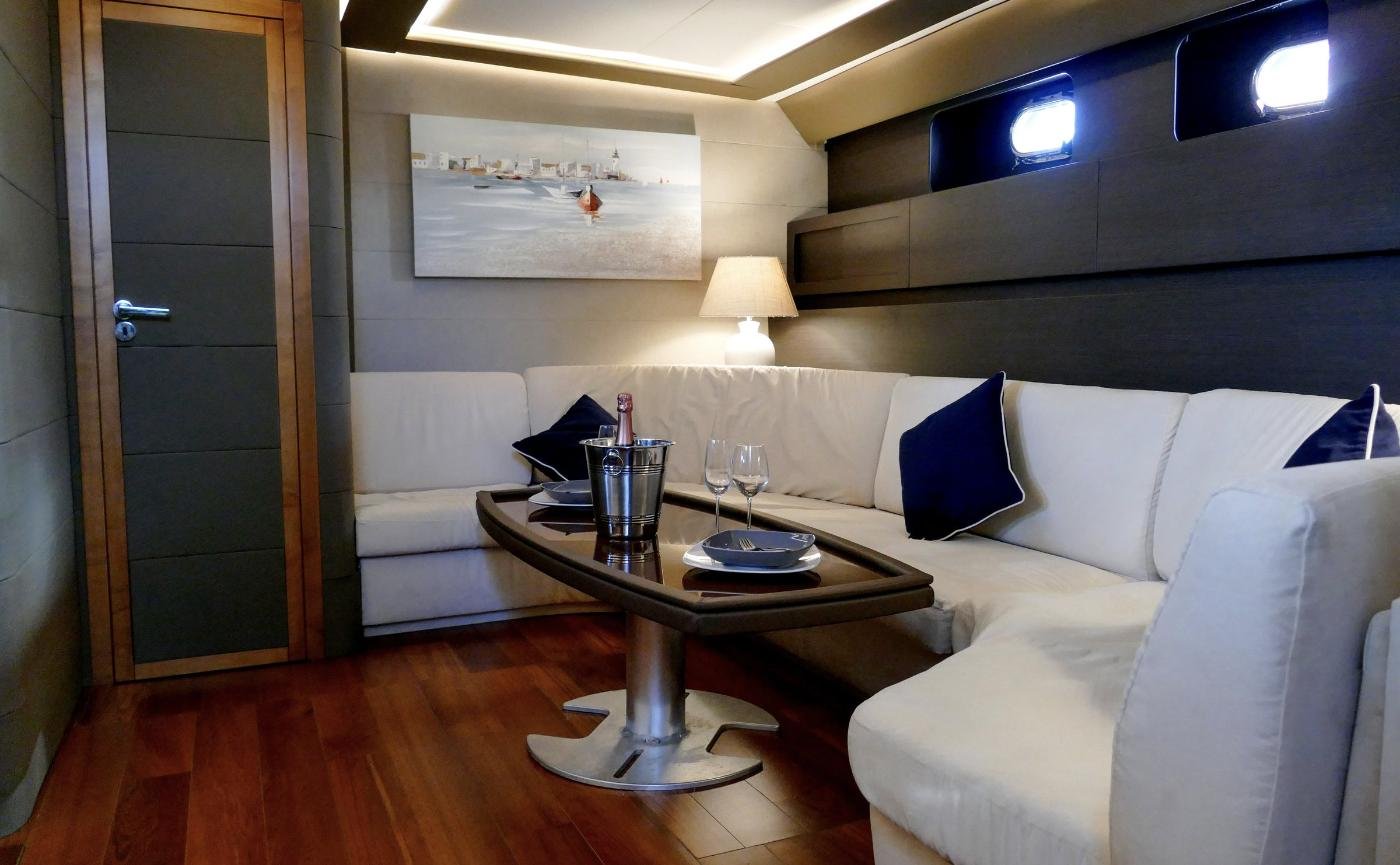 Main saloon with L-shaped settee and lacquered joinery aboard a 23m motor yacht