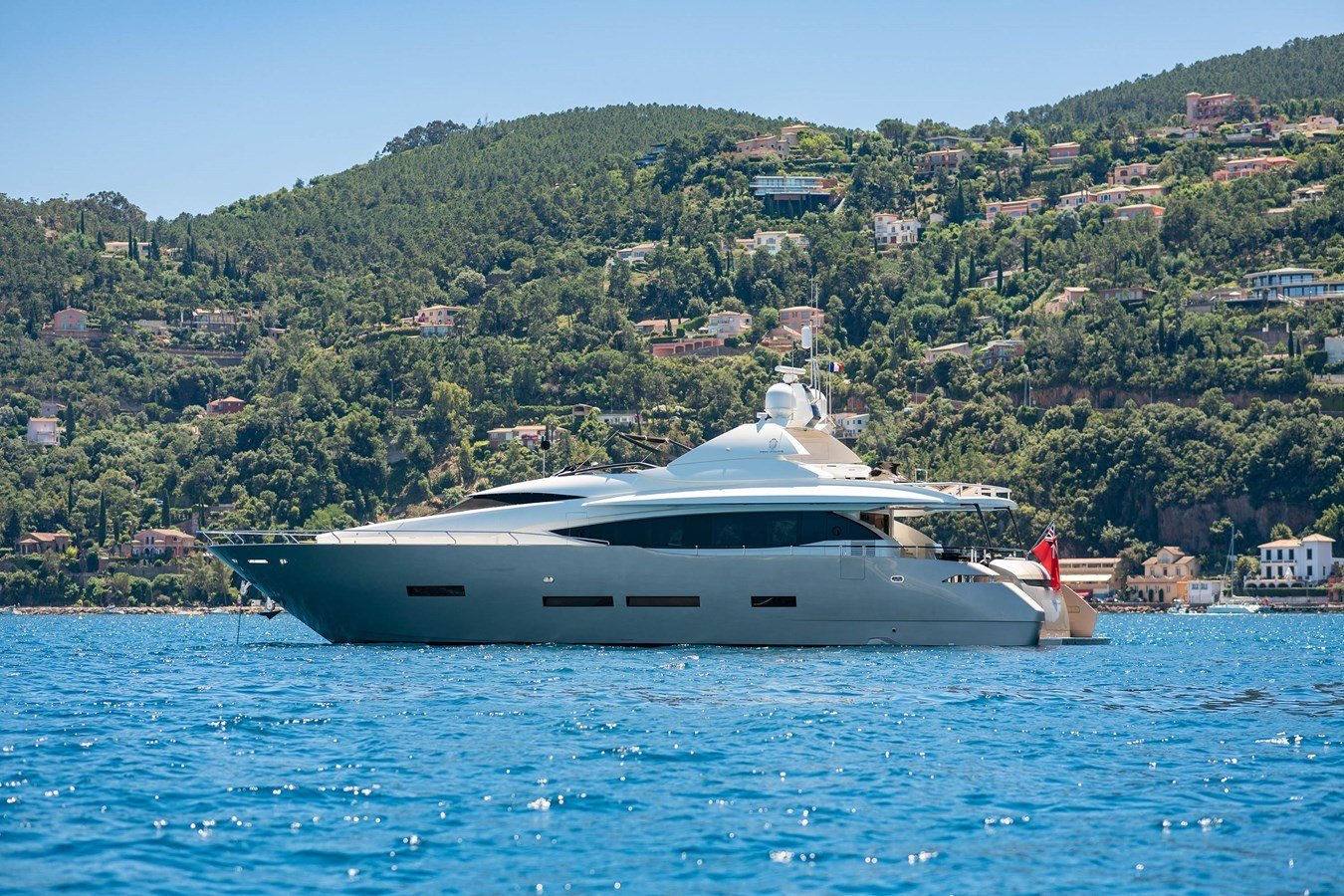 Peri 37 charter Göcek running close inshore below a pine-covered hillside
