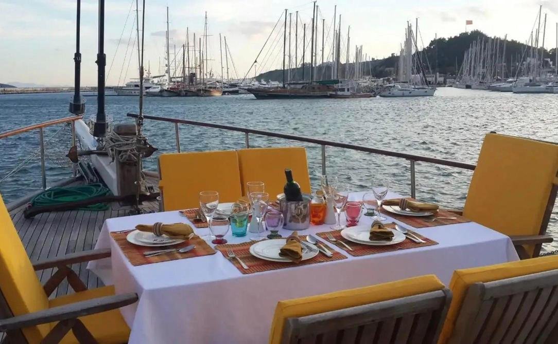 Bodrum romantik gulet kiralama - limana bakan, akşam yemeği için kurulmuş masa