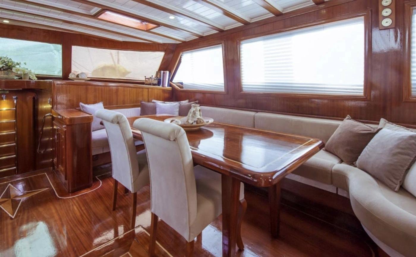 Sailing gulet charter Marmaris - saloon dining table with banquette seating