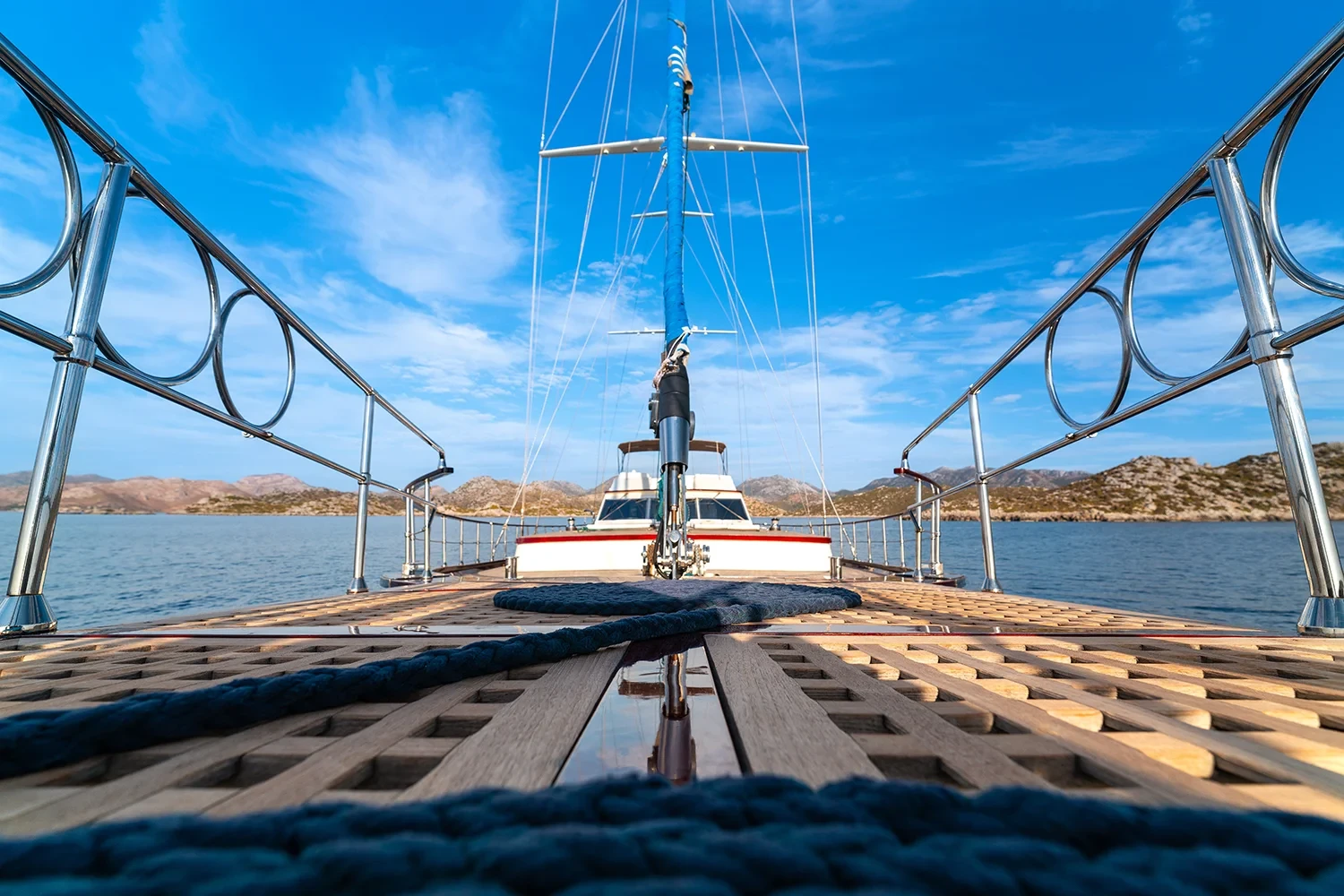 Foredeck of a sailing yacht charter in Bodrum looking forward over the teak deck to the anchor windlass and bowsprit