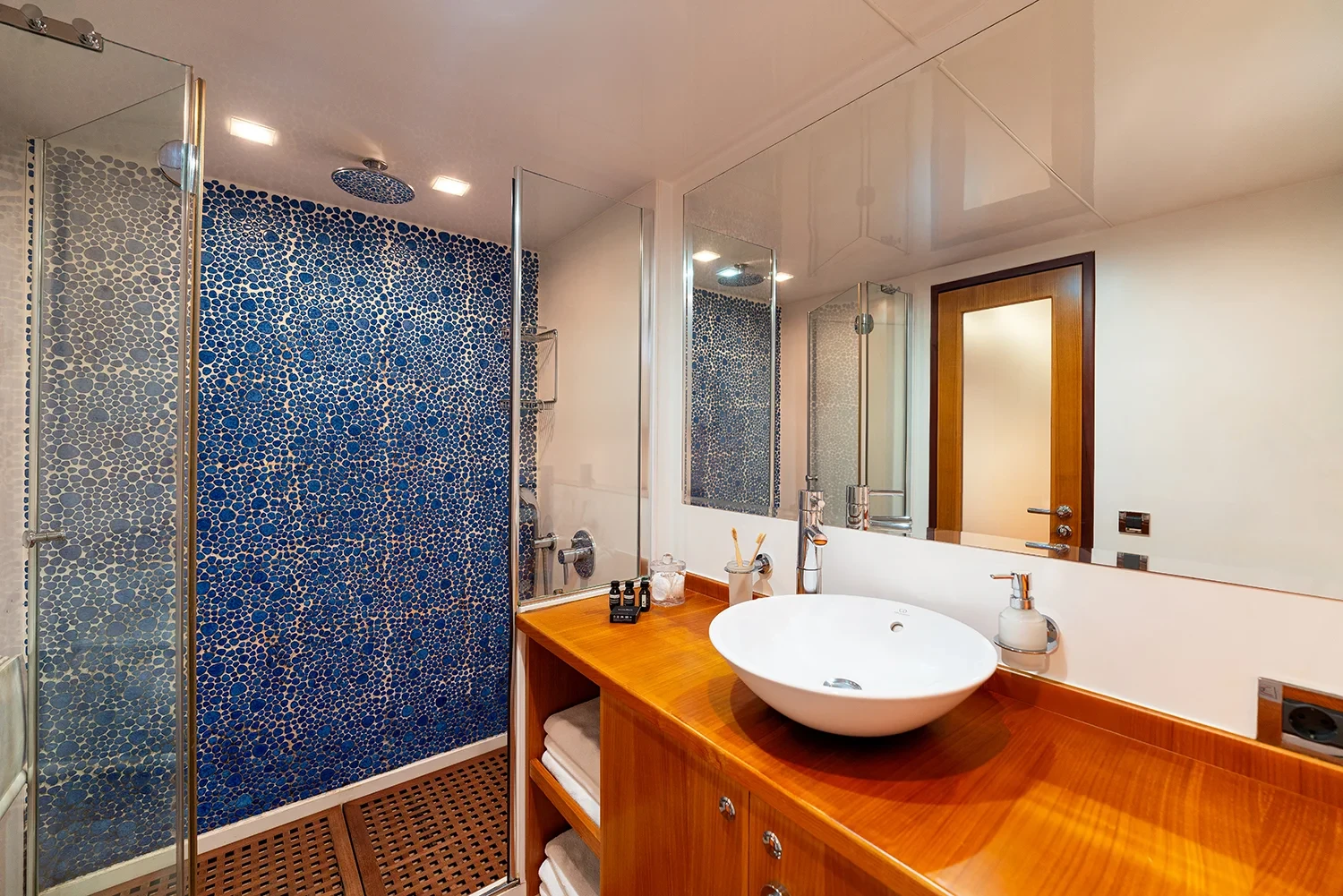 En-suite bathroom of the master cabin aboard a sailing yacht charter in Bodrum with blue mosaic tile and separate shower