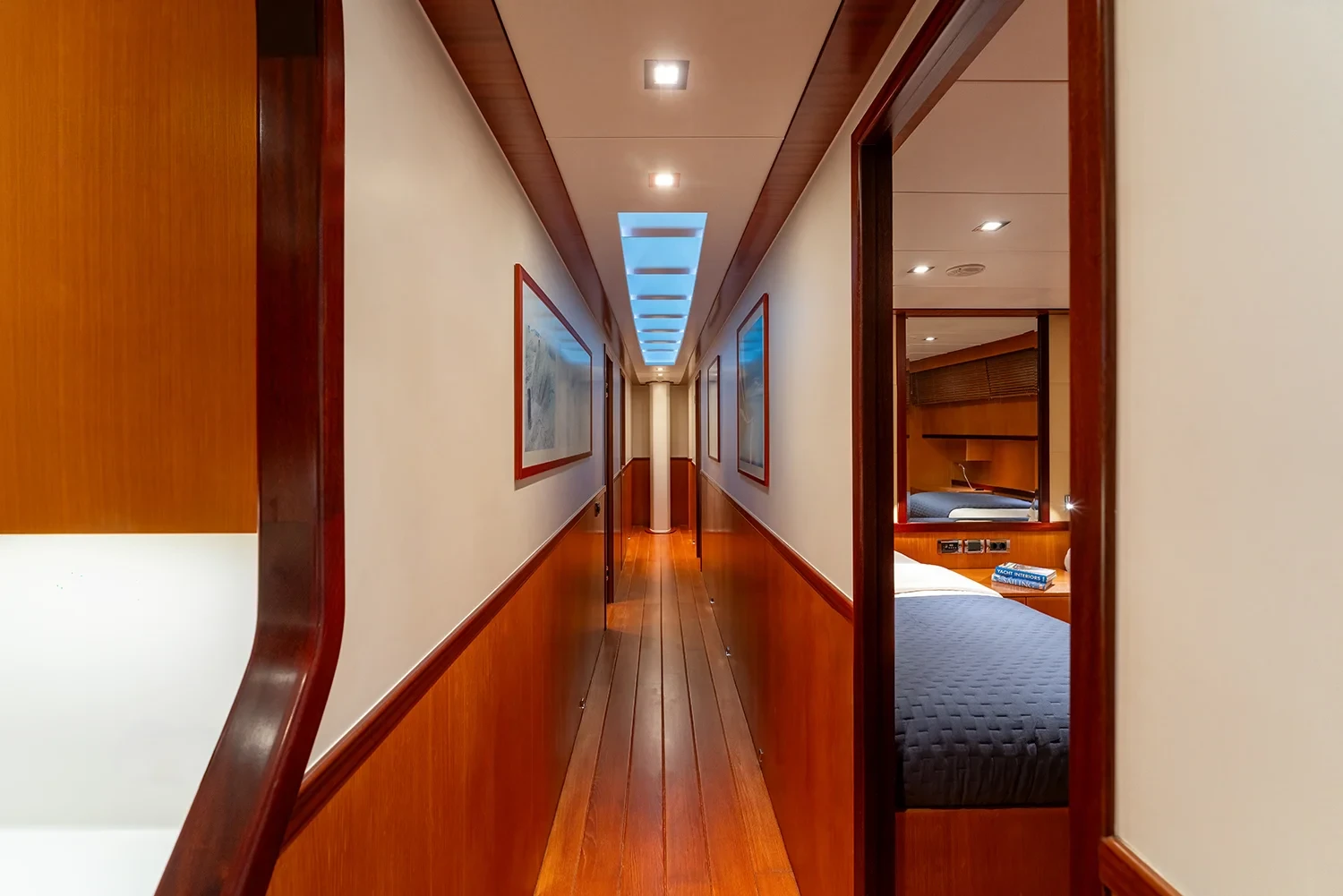 Passageway aboard a sailing yacht charter in Bodrum leading past cabin doors, framed artwork on the walls