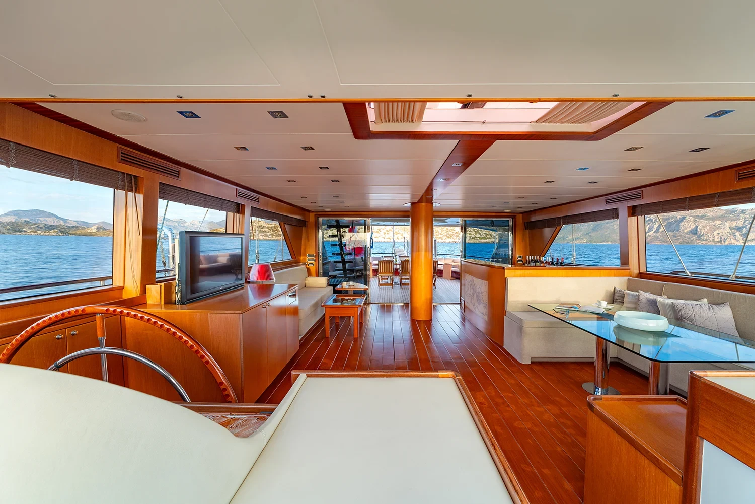 Saloon of a sailing yacht charter in Bodrum with panoramic windows, interior helm and dining table