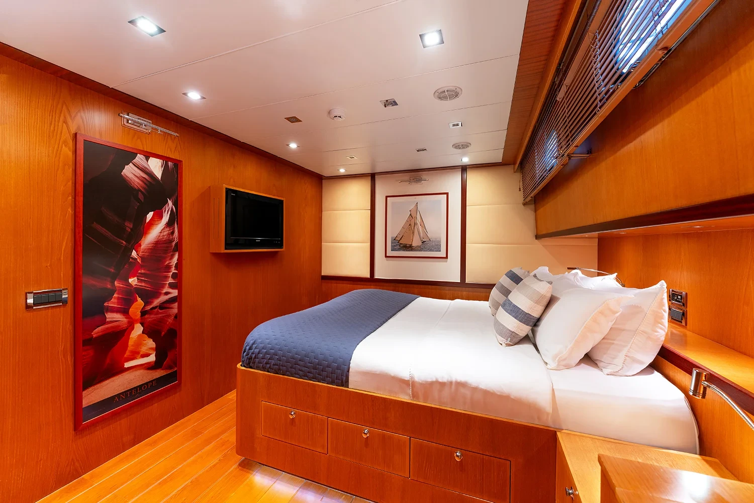 VIP double cabin aboard a sailing yacht charter in Bodrum finished in warm timber with a mounted television