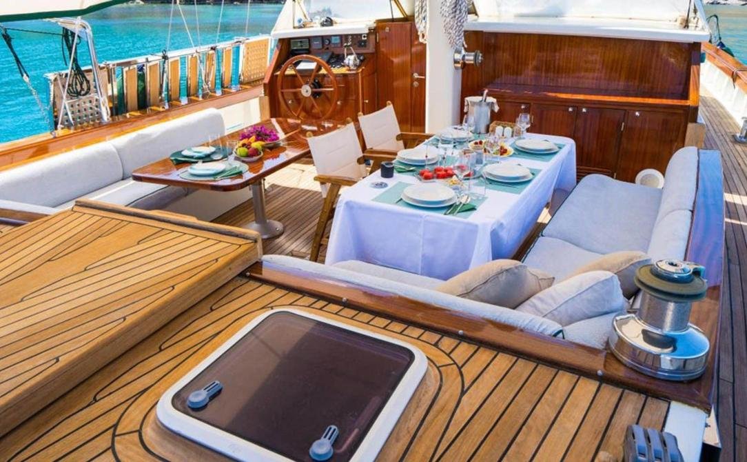 Bodrum signature gulet kiralama - ahşap dümen dolabının yanında kıç güverte yemek alanı