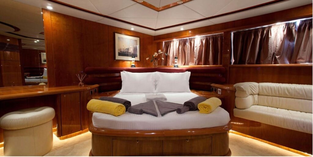 Full-beam master cabin with island berth and settee aboard a Sunseeker Manhattan 74 charter yacht