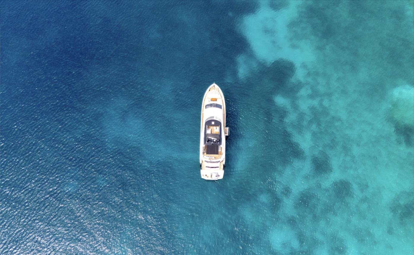 Turkuaz su üzerinde demirli Sunseeker 86 Yacht, havadan görünüm
