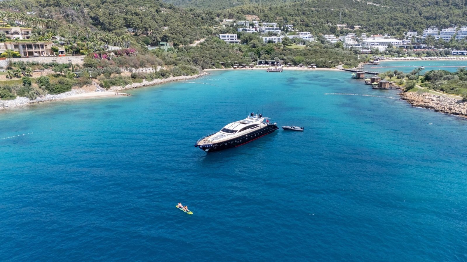 Tecnomar 116 charter Bodrum anchored in a turquoise bay on the Bodrum coast, aerial view
