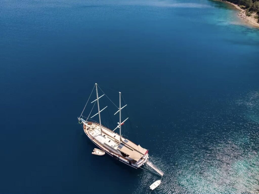 Marmaris VIP gulet kiralama - yanında yardımcı botla demirli guletin tepeden havadan görünümü