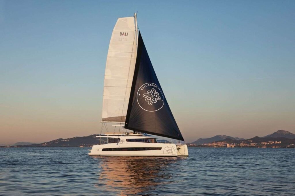Bali 5.8 charter Ibiza crewed catamaran sailing off the Balearic coast at sunset