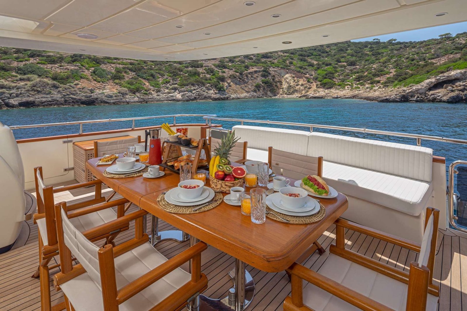 Aft deck dining table set for ten guests on a Greek charter yacht