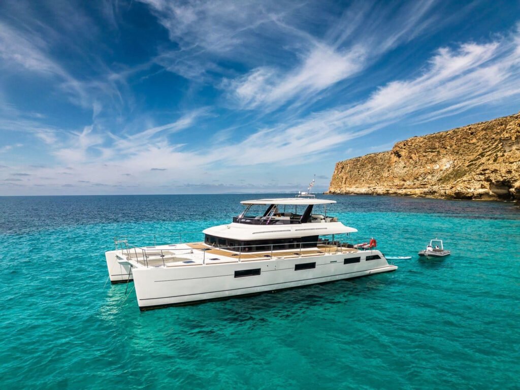 Lagoon 630 power catamaran at anchor in a turquoise Balearic cove near Ibiza