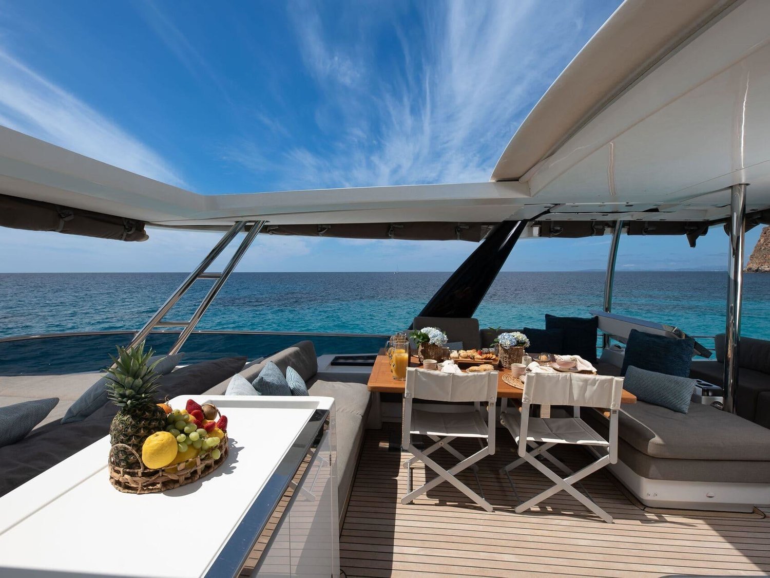 Shaded flybridge dining table on the Lagoon 630 charter Ibiza catamaran