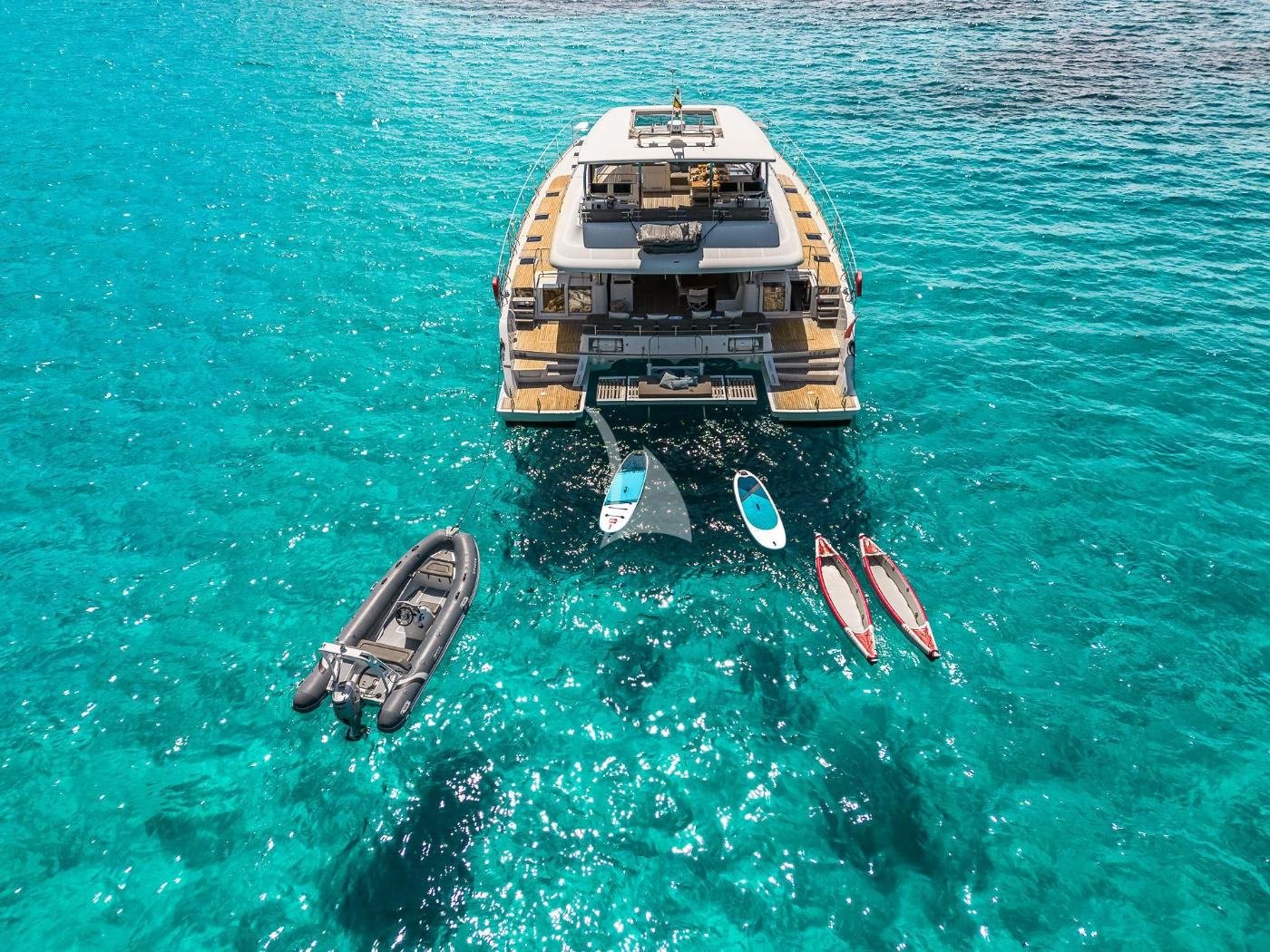 Paddleboardlar ve deniz oyuncaklarıyla demirli İbiza kiralık Lagoon 630 motorlu katamaran