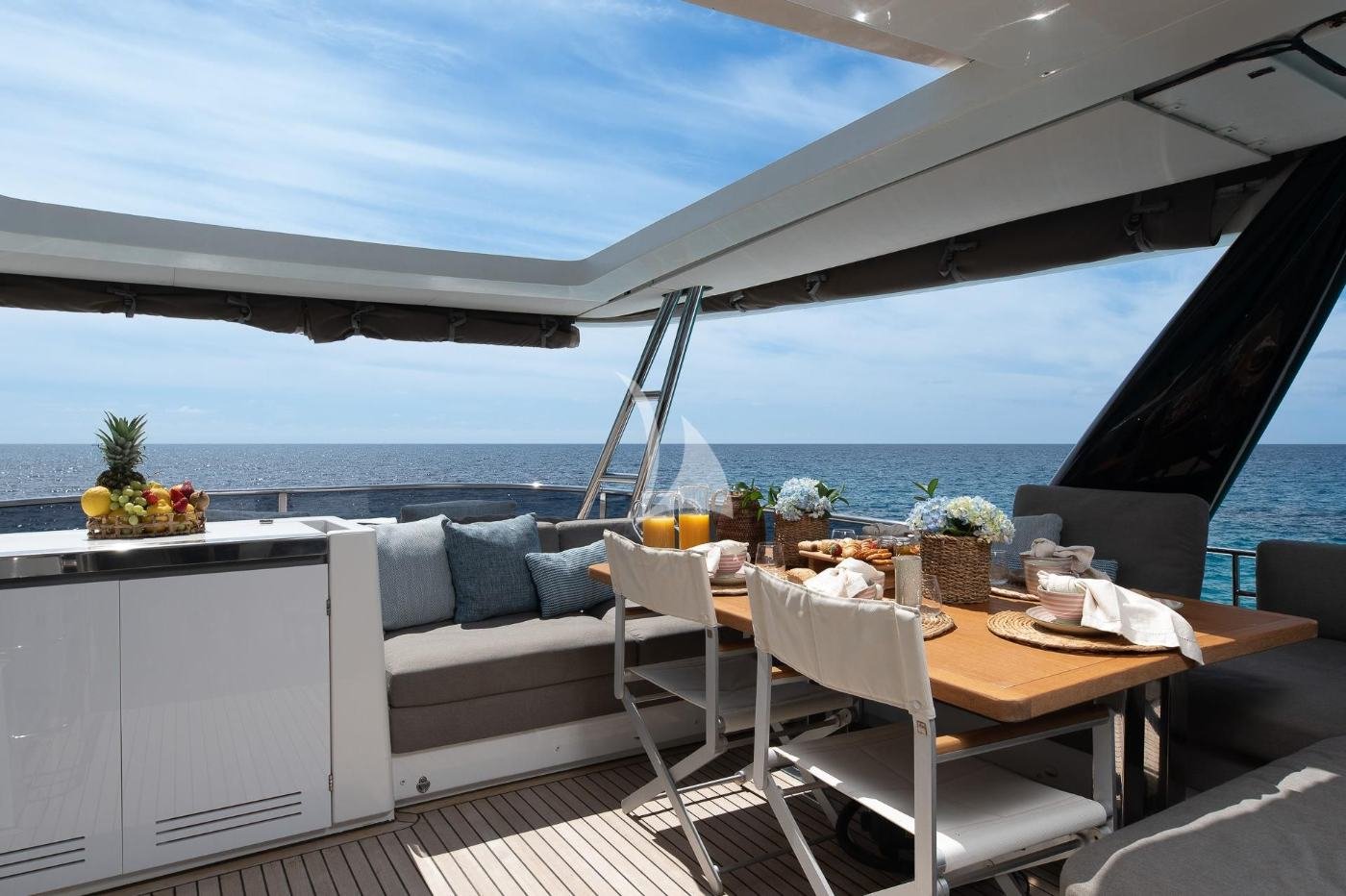İbiza kiralık Lagoon 630 katamaranda gölgeli flybridge yemek masası