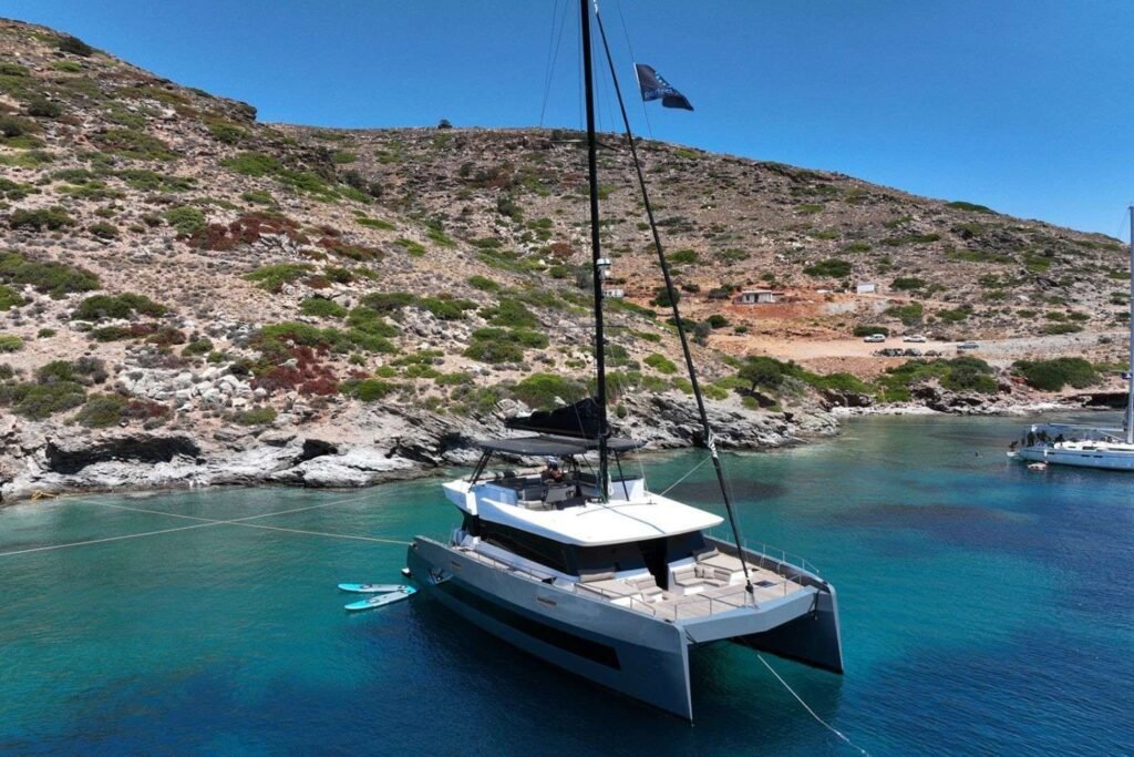 Moon Yacht 60 charter Athens – the power catamaran at anchor in a Greek cove