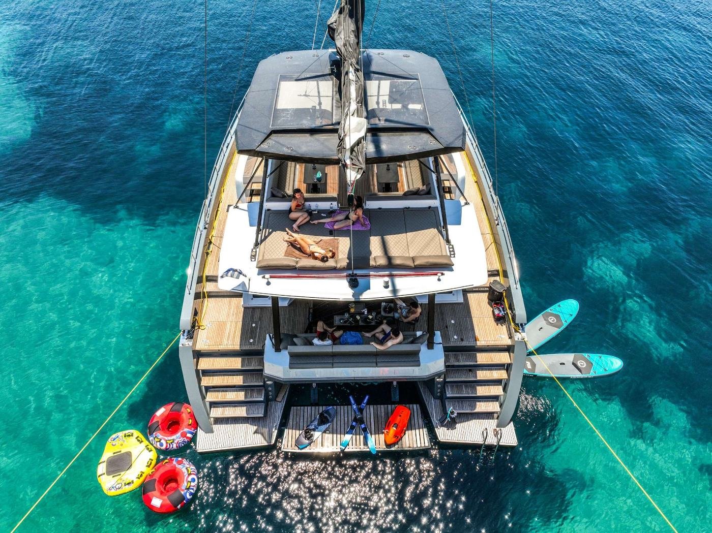 Aerial view of the Moon Yacht 60 charter Athens catamaran with water toys off the swim platform