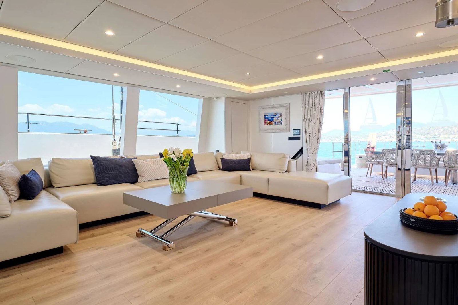 Atina kiralık Sunreef 80 katamaranda tam genişlikte camlı ve oturma gruplu ana salon