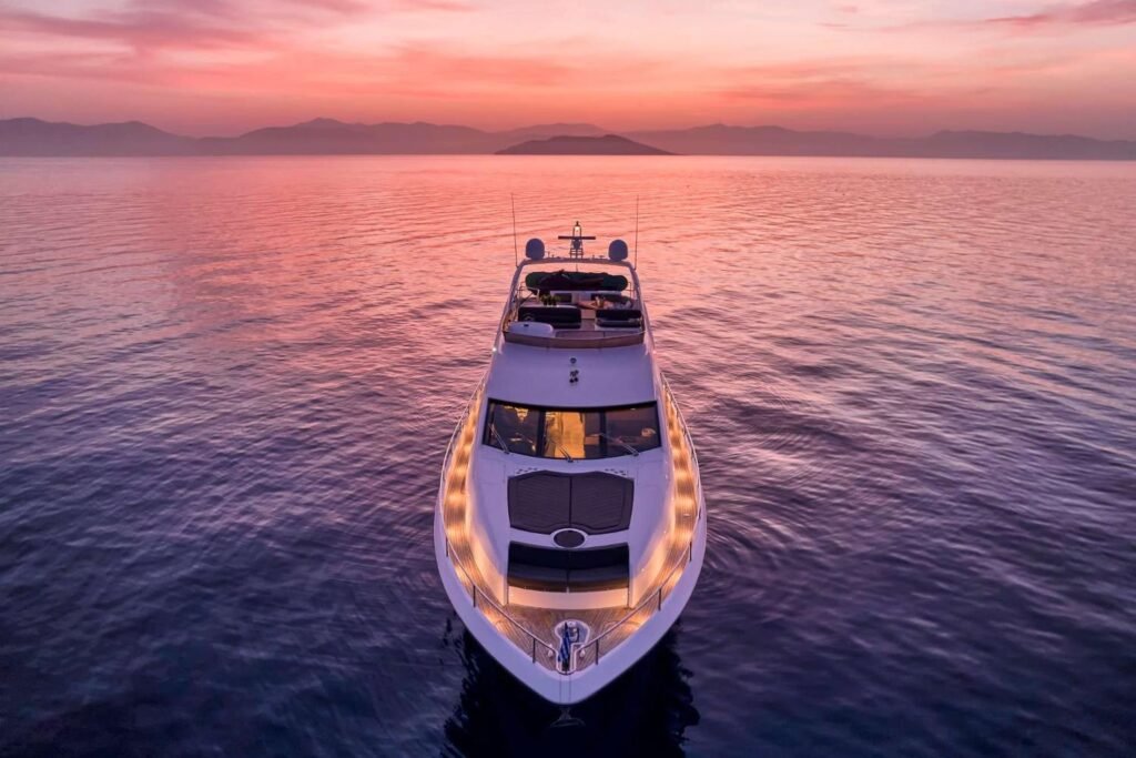 Sunseeker 75 charter Athens flybridge motor yacht lit at anchor at sunset in the Cyclades